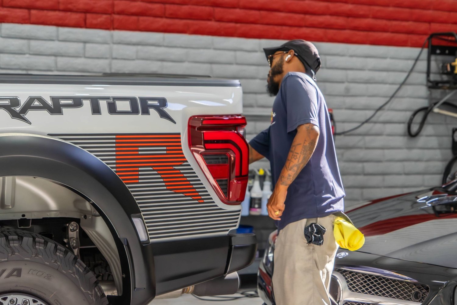 Technician working on a white Ford Raptor inside the Scottsdale shop